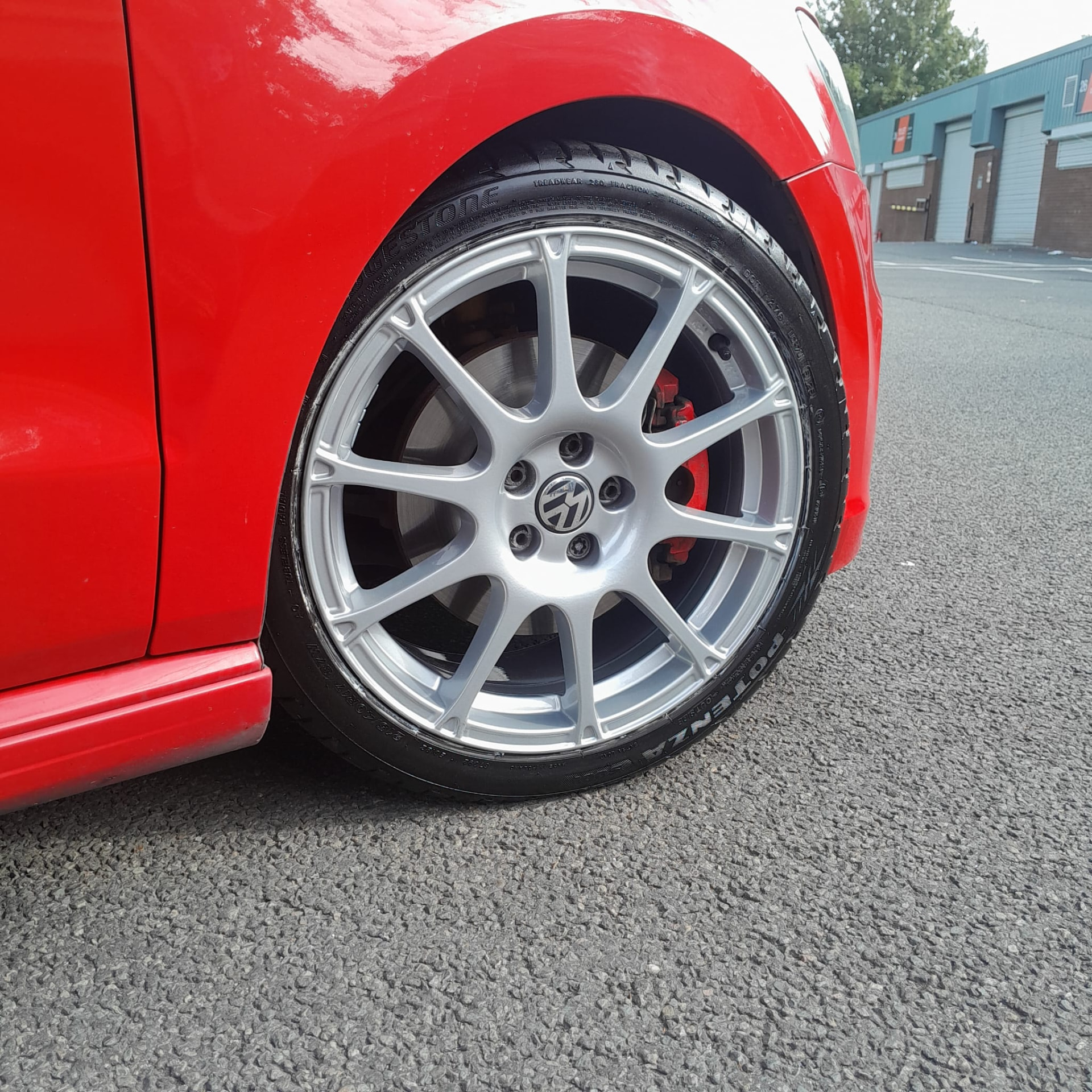 Silver alloy wheel fitted to a red Volkswagen