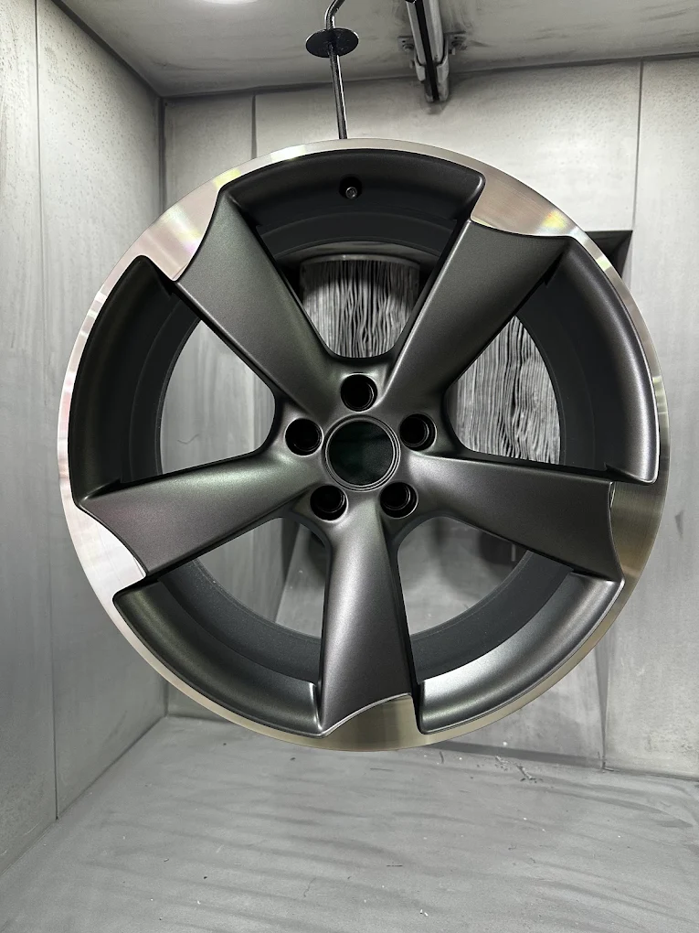 Silver grey refinished alloy wheel in the spray booth