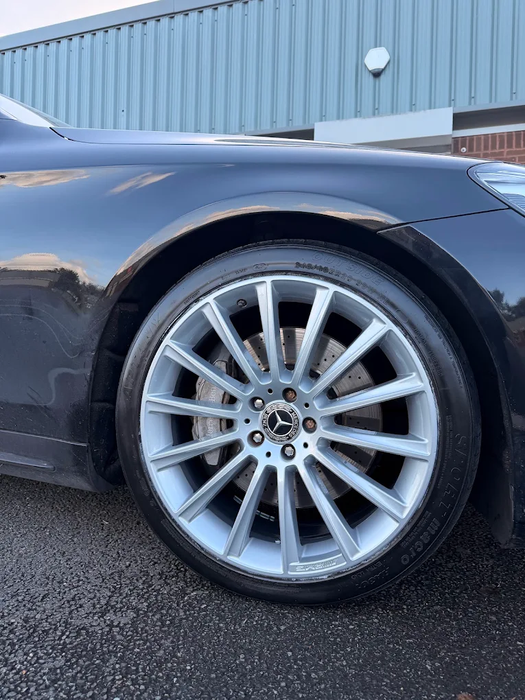 Close-up of a dark grey alloy wheel with a diamond cut face